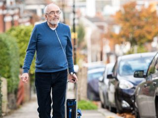 a man using oxygen while walking down a street